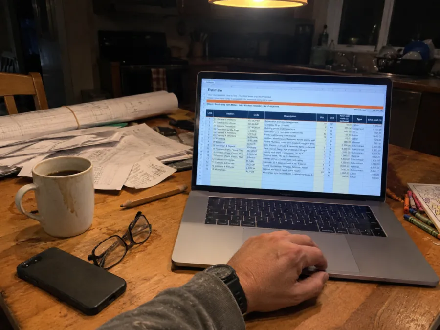 Contractor preparing an estimate at the kitchen table in the evening
